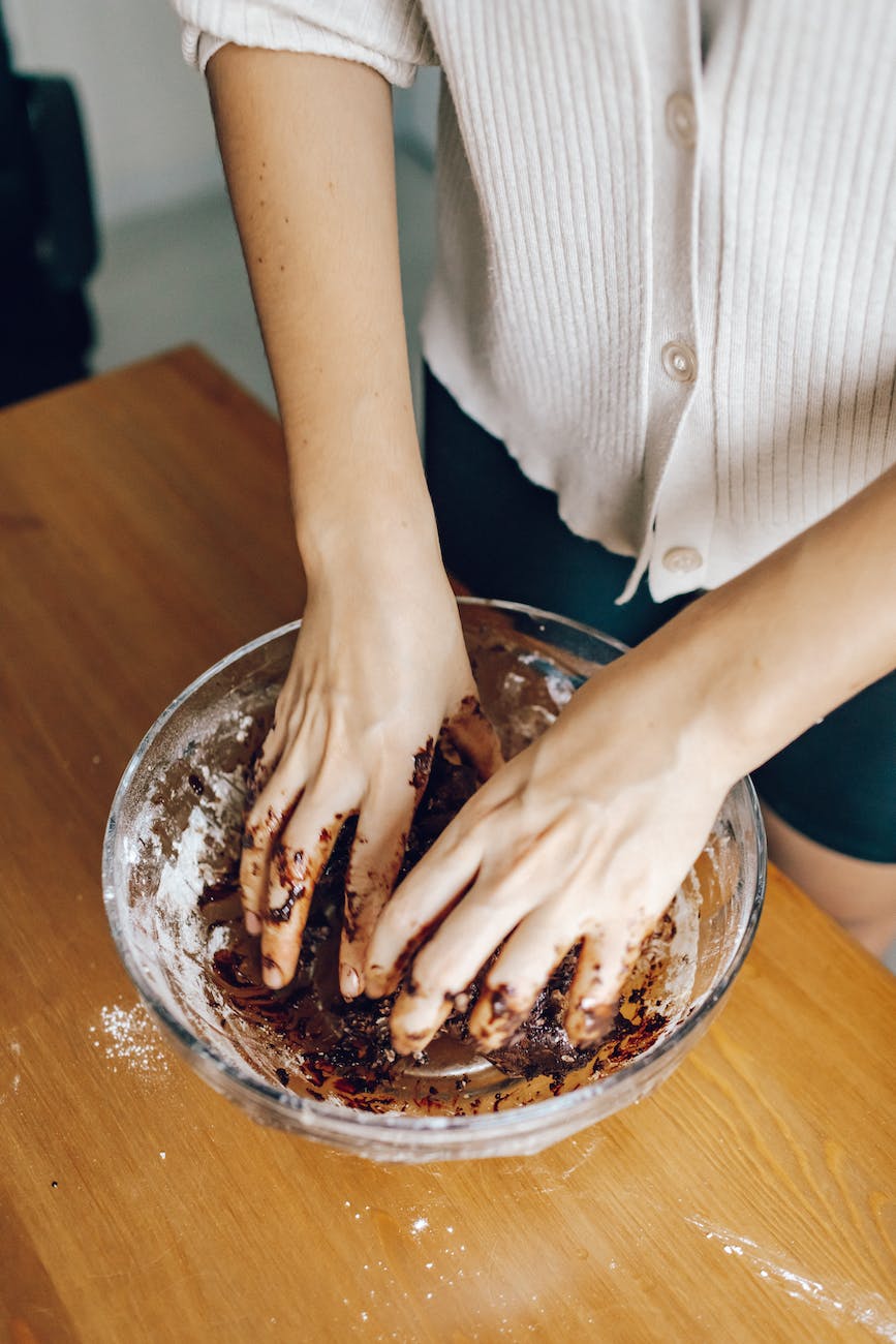 unrecognizable cook preparing chocolate cake in bowl